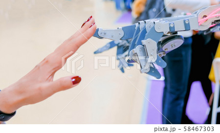 Woman touching futuristic robotic hand Woman touching futuristic robotic hand 58467303