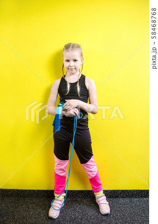 Theme sport and health. Beautiful caucasian child girl with pigtails posing yellow background with 58468768