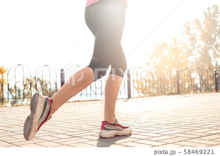 Healthy Lifestyle. Young woman jogging outdoors autumn season feet close-up Healthy Lifestyle. Young woman jogging outdoors autumn season feet close-up 58469221