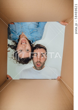 Curious wife and husband unpacking carboard boxes. Curious wife and husband unpacking carboard boxes. 58469621