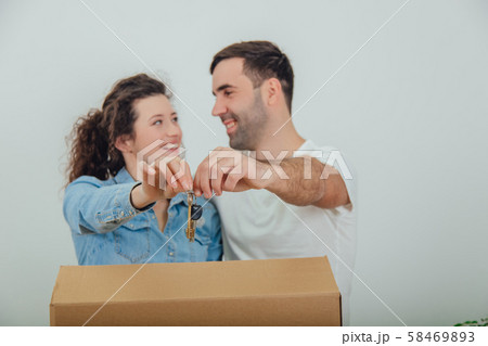 Joyfull wife and husband standing behind the big carton box, , holding together in front of the 58469893