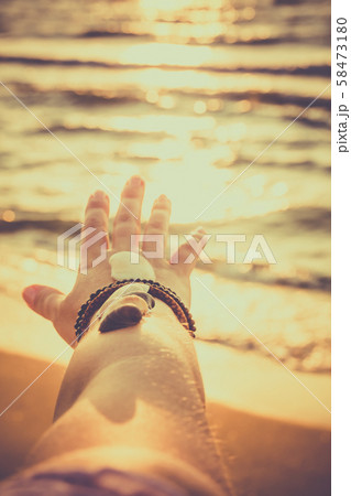 Woman holds seashells on her hand and points 58473180