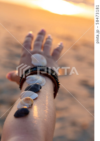 Woman holds seashells on her hand and points 58473181