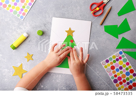 The child makes a greeting card Christmas paper collage. Children's art project craft for kids 58473535