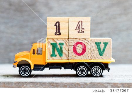 Truck hold letter block in word 14nov on wood background Truck hold letter block in word 14nov on wood background 58477067