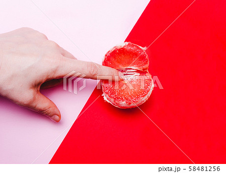 fingers in grapefruit, vagina symbol on a red fingers in grapefruit, vagina symbol on a red 58481256