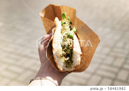 vegetarian hot dog with soy sausage in female hand vegetarian hot dog with soy sausage in female hand 58481982