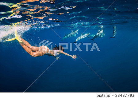 Young woman swim underwater with dolphins in blue ocean. Mauritius 58487792
