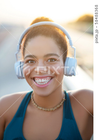 Dark-eyed woman showing toothy smile after running Dark-eyed woman showing toothy smile after running 58488368