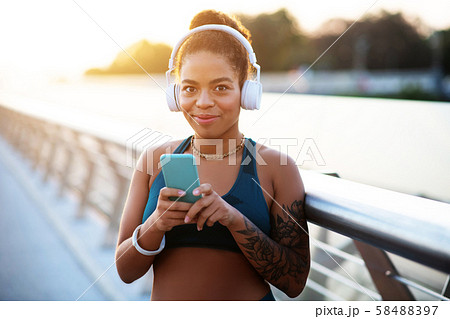 Dark-eyed woman using sport app before starting morning run 58488397