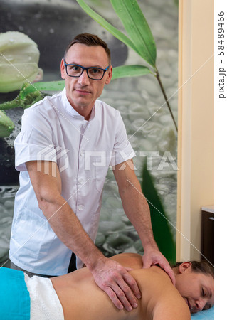 Osteopath therapist, makes the manipulation and massage the patient with an injury. 58489466