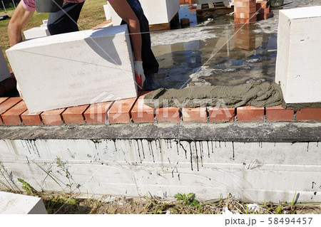 The worker begins the first row of masonry 58494457