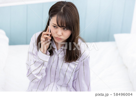 若い女性 携帯電話 不機嫌 58496004