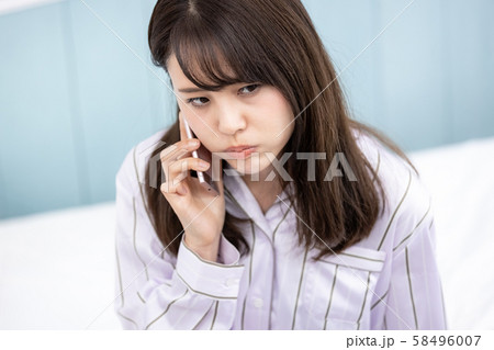 若い女性 携帯電話 不機嫌 58496007