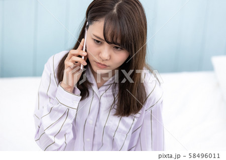 若い女性 携帯電話 不機嫌 58496011