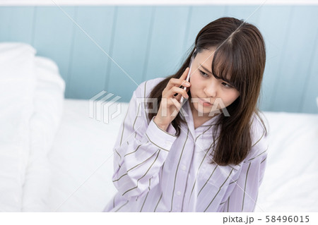 若い女性 携帯電話 不機嫌 58496015