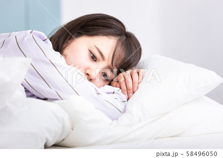 ベッドの中の女性 枕にうつ伏せ アンニュイ ベッドの中の女性 枕にうつ伏せ アンニュイ 58496050