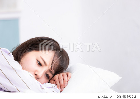 ベッドの中の女性 枕にうつ伏せ アンニュイ 58496052