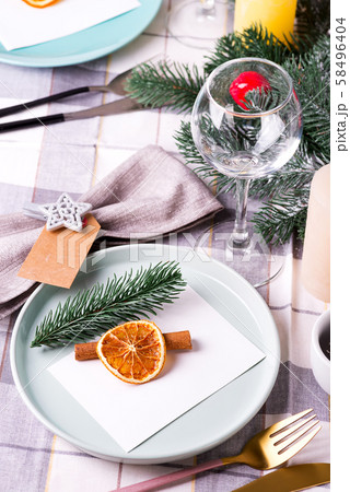 Festive Christmas and New Year table setting with dry orange and cinnamon on a gray textile. Dining Festive Christmas and New Year table setting with dry orange and cinnamon on a gray textile. Dining 58496404