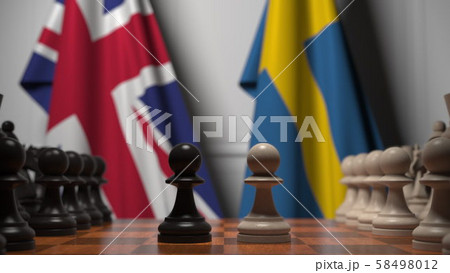 Flags of Great Britain and Sweden behind pawns on the chessboard. Chess game or political rivalry 58498012