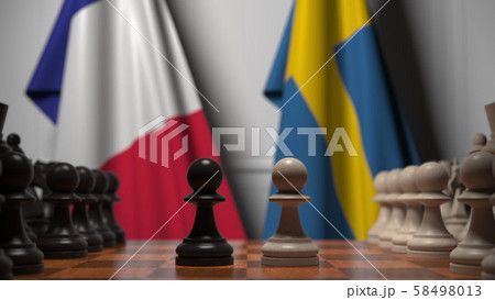 Flags of France and Sweden behind pawns on the chessboard. Chess game or political rivalry related 58498013