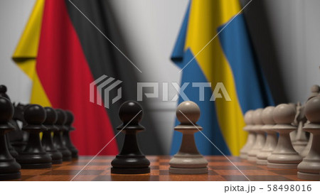 Flags of Germany and Sweden behind pawns on the chessboard. Chess game or political rivalry related Flags of Germany and Sweden behind pawns on the chessboard. Chess game or political rivalry related 58498016