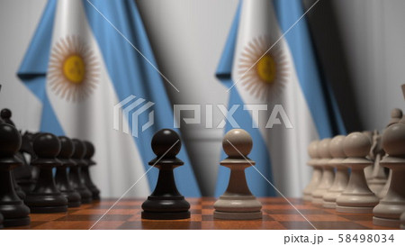 Flags of Argentina behind pawns on the chessboard. Chess game or political rivalry related 3D 58498034