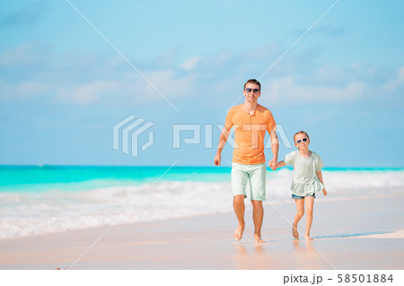 Little girl and happy dad having fun during beach vacation 58501884