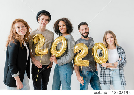 Group of multicultural friends holding golden balloons in form of numbers 58502192