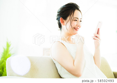 女性 スマホ 若い女性 リビング かわいい ライフスタイル 女性 スマホ 若い女性 リビング かわいい ライフスタイル 58502493