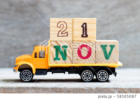 Truck hold letter block in word 21nov on wood background  58505087