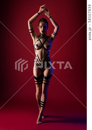 Nude brunette with black tape bodyart shot Nude brunette with black tape bodyart shot 58507839