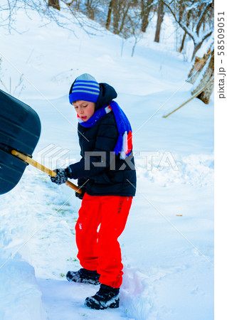 Cleaning snow in winter, the boy shovels snow. Cleaning snow in winter, the boy shovels snow. 58509051