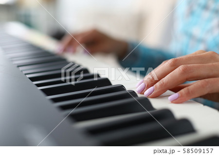 Pretty woman giving lesson to play piano 58509157