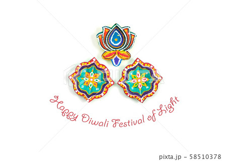 Happy Diwali - Clay Diya lamps lit during Dipavali, Hindu festival of lights celebration. Colorful traditional oil lamp diya on white background. Copy space for text. 58510378