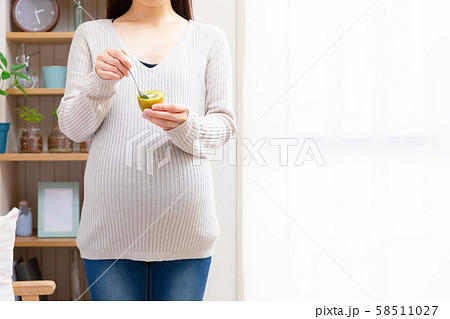 キウイフルーツを食べる妊婦 58511027