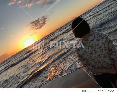 夕焼けを見る女性 58511472