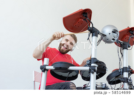 People, music and hobby concept - Happy man who spends his free time playing drums 58514699