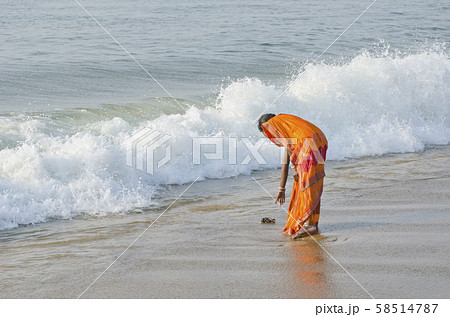 indian woman with colorful sari on sea beach 58514787