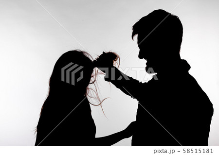 Aggression and abuse concept - man and woman expressing domestic violence in studio silhouette 58515181