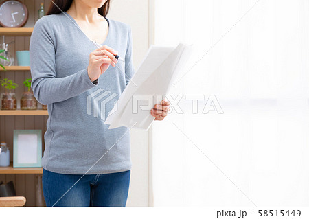 自宅で書類をチェックする女性 58515449