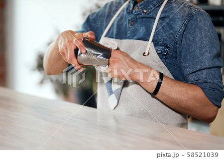 Bearded barista drys jug with towel Bearded barista drys jug with towel 58521039