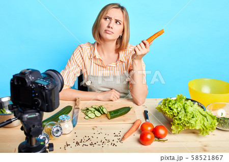 Female nutrition expert looks aside, thinks what to cook out of raw vegetable Female nutrition expert looks aside, thinks what to cook out of raw vegetable 58521867
