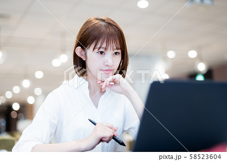 おしゃれなオフィスでノートPCを使って働く20代女性 58523604