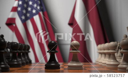 Flags of USA and Latvia behind pawns on the chessboard. Chess game or political rivalry related 3D Flags of USA and Latvia behind pawns on the chessboard. Chess game or political rivalry related 3D 58523757