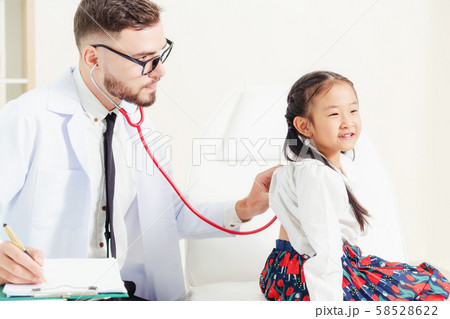 Doctor examining little happy kid in hospital. Doctor examining little happy kid in hospital. 58528622