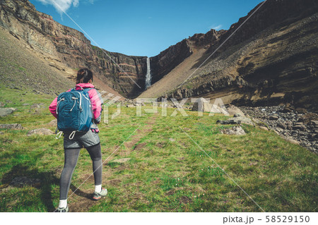 Traveler hiking at Hengifoss Waterfall, Iceland. Traveler hiking at Hengifoss Waterfall, Iceland. 58529150