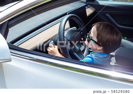 Toddler boy playing in a car Toddler boy playing in a car 58529380