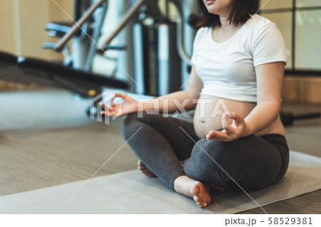 Active pregnant woman exercise in fitness center. Active pregnant woman exercise in fitness center. 58529381