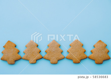 Holiday cookies in the shape of Christmas tree on light blue background. Space for text. 58536683